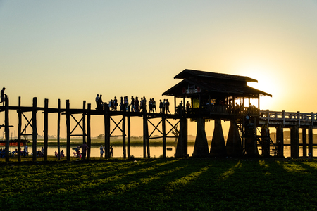 Silhouetted people on U Bein Bridge at sunset, Amarapura, Mandalay region, Myanmarのeditorial素材