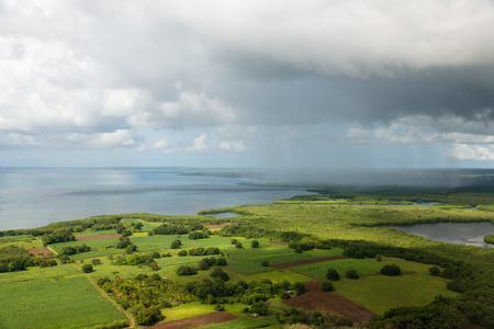 Isolated rainshower with sunshine, aerial approch to Guadeloupe during the tropical rain seasonの写真素材