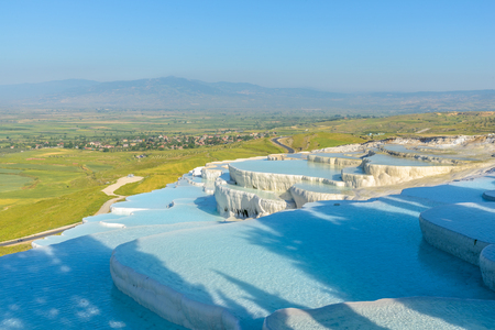 The enchanting pools of Pamukkale in Turkey. Pamukkale contains hot springs and travertines, terraces of carbonate minerals left by the flowing water.の写真素材