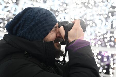 Professional photographer on ground, takes images of christmas lights in the middle of the nightの写真素材