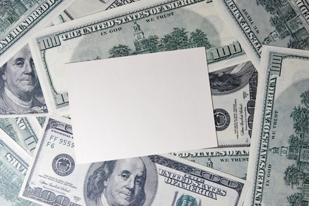 White card on the background of hundred dollar billsの写真素材