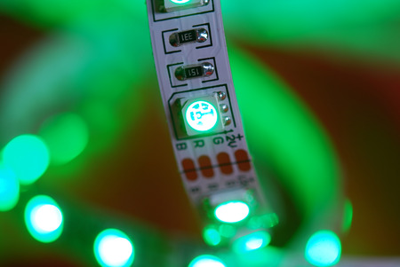 Green led strip on the background of red textileの写真素材