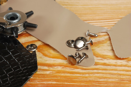 Workplace tailor with pieces of leather, tool for punching holes and rivets