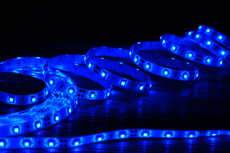 Blue led strip on a wooden board on the black backgroundの写真素材