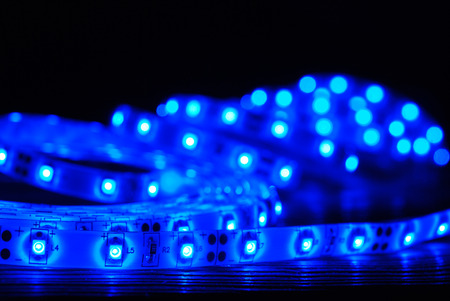 Blue led strip on a wooden board on the black backgroundの写真素材