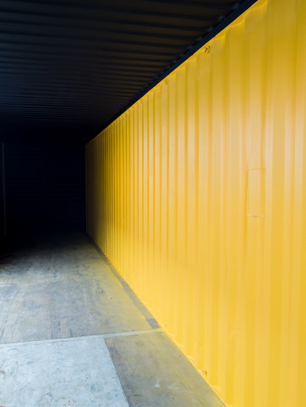 Cargo container deep inside to the dark with yellow wallの写真素材