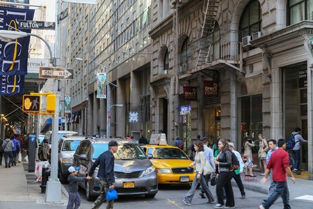 A street with shops, cars and pedestrians in Manhattanのeditorial素材