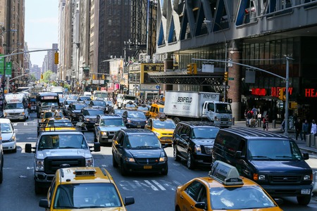 Many cars driving through a congested street in NY