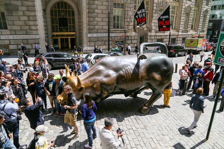 Tourists posing with Charging Bull in New Yorkのeditorial素材