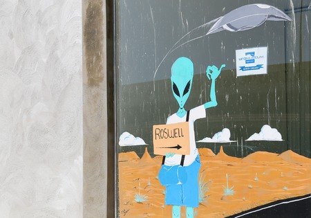 Painting of an alien pointing towards the International UFO Museum in Roswell, New Mexicoのeditorial素材