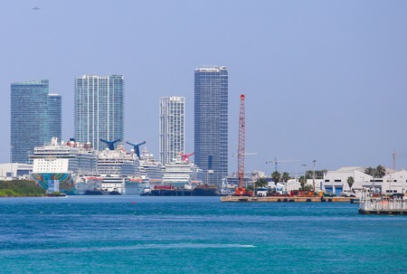 Several cruise ships at the Port of Miami with skyscrapers in the back.のeditorial素材