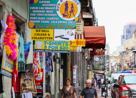 New Orleans, USA - May 14, 2015: Several shops on Bourbon Street in French Quarter selling different kinds of souvenirs and gifts. Pedestrians are walking on the sidewalk.のeditorial素材