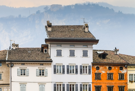 Trento, Italy - March 21, 2017: Row of houses with diverse facades on the square Pizza Duomo with the Alps in the back.のeditorial素材