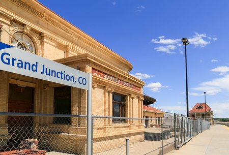 Grand Junction, USA - May 28, 2016: Old building of the train station with old lettering on it and a modern Amtrak sign in front.のeditorial素材