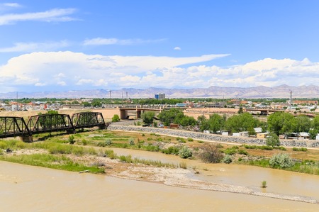 Grand Junction, USA - May 28, 2016: Railroad bridge over the confluence of the Gunnison River and Colorado River with part of the city and the Book Cliffs in the back.のeditorial素材