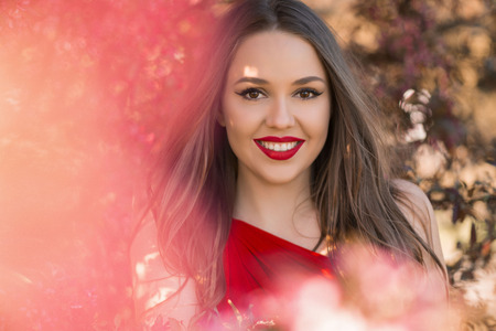 Smiling woman with long hair and red lipsの写真素材