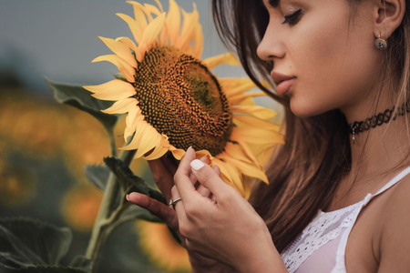 Young attractive woman holding a sunflowerの写真素材