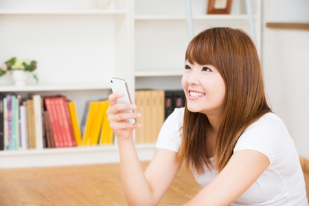 The Young woman who uses the smartphone in a roomの写真素材