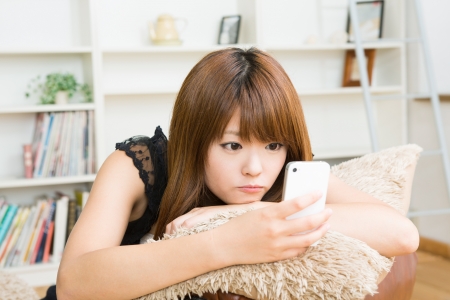 The Young woman who uses the smartphone in a roomの写真素材