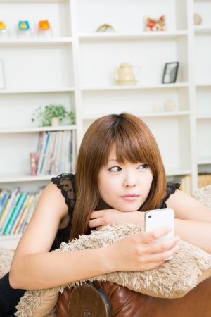 The Young woman who uses the smartphone in a roomの写真素材