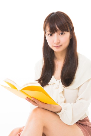 young attractive asian woman who reads a bookの写真素材