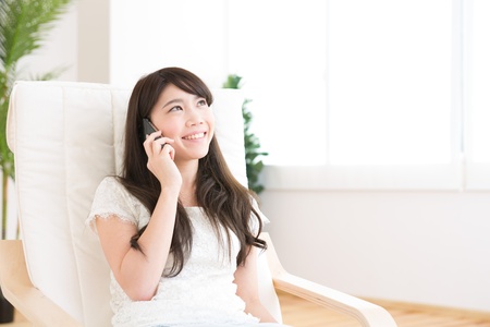 The Young woman who talks on the telephone in a roomの写真素材