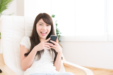 The Young woman who uses the smartphone in a roomの写真素材