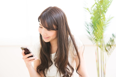 The Young woman who uses the smartphone in a roomの写真素材