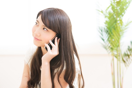 The Young woman who talks on the telephone in a roomの写真素材