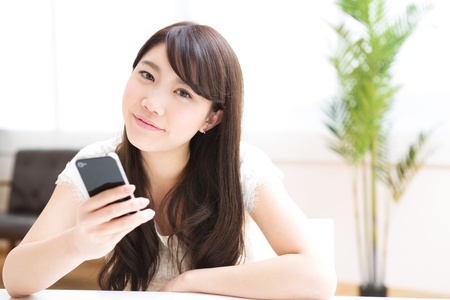 The Young woman who uses the smartphone in a roomの写真素材