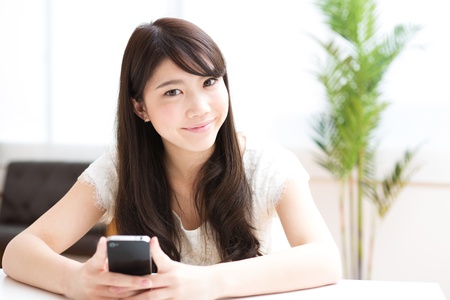 The Young woman who uses the smartphone in a roomの写真素材