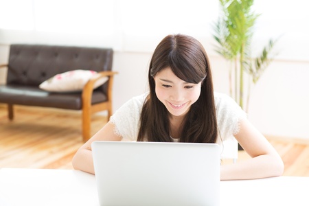The Young woman who uses the computer in a roomの写真素材