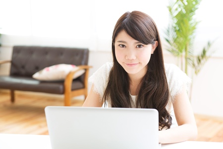 The Young woman who uses the computer in a roomの写真素材