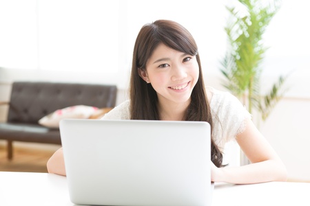 The Young woman who uses the computer in a roomの写真素材