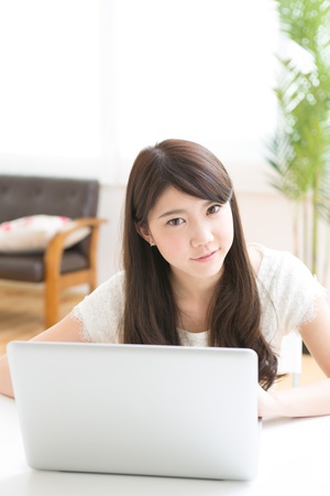 The Young woman who uses the computer in a roomの写真素材