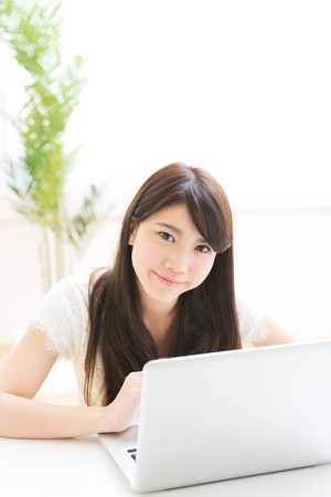 The Young woman who uses the computer in a roomの写真素材