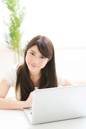 The Young woman who uses the computer in a roomの写真素材