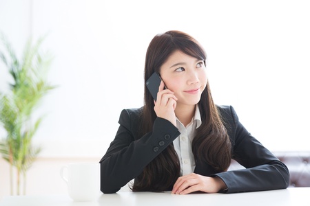 The Young businesswoman who talks on the telephoneの写真素材