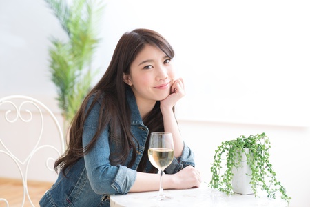 The young woman who drinks wine in a roomの写真素材