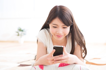 The Young woman who uses the smartphone in a roomの写真素材