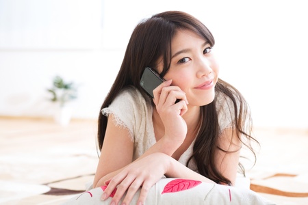 The Young woman who talks on the telephone in a roomの写真素材