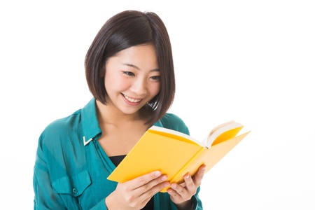 young attractive asian woman who reads a bookの写真素材