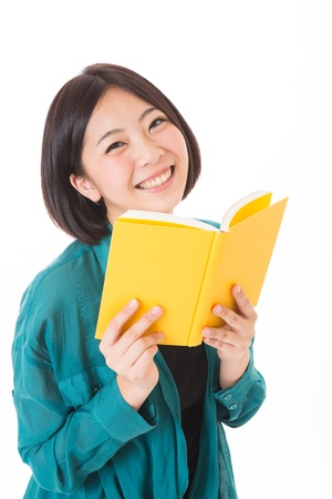 young attractive asian woman who reads a bookの写真素材