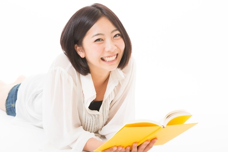young attractive asian woman who reads a bookの写真素材