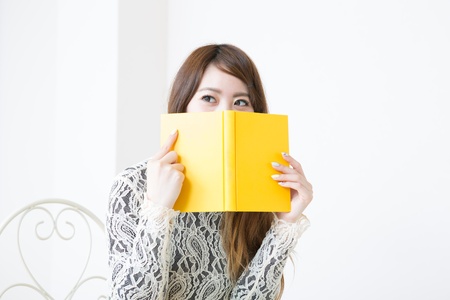 young attractive asian woman who reads a bookの写真素材