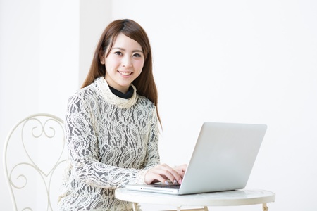 The Young woman who uses the computer in a roomの写真素材