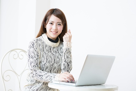 The Young woman who uses the computer in a roomの写真素材