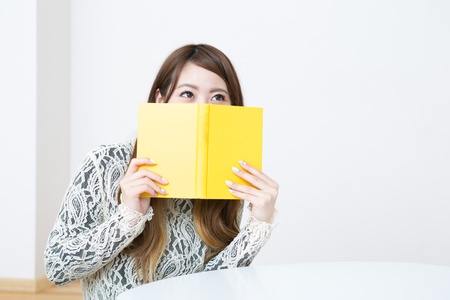 young attractive asian woman who reads a bookの写真素材