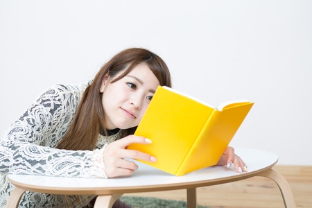 young attractive asian woman who reads a bookの写真素材