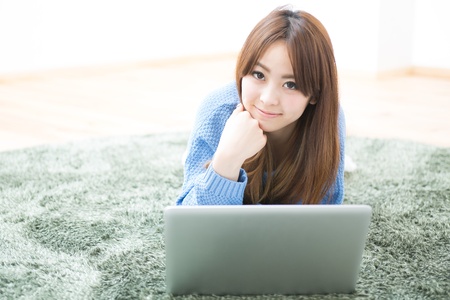 The Young woman who uses the computer in a roomの写真素材